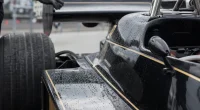 Svart-guldlackerad klassisk F1-bil i depån på Silverstone